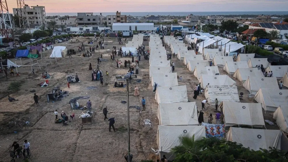 Des Palestiniens s'abritent dans un camp de tentes temporaire mis en place pour ceux qui ont été déplacés de leurs maisons par les ordres d'évacuation et les frappes aériennes d'Israël, à Khan Younis, dans le sud de la bande de Gaza (Crédit photo : Bloomberg)