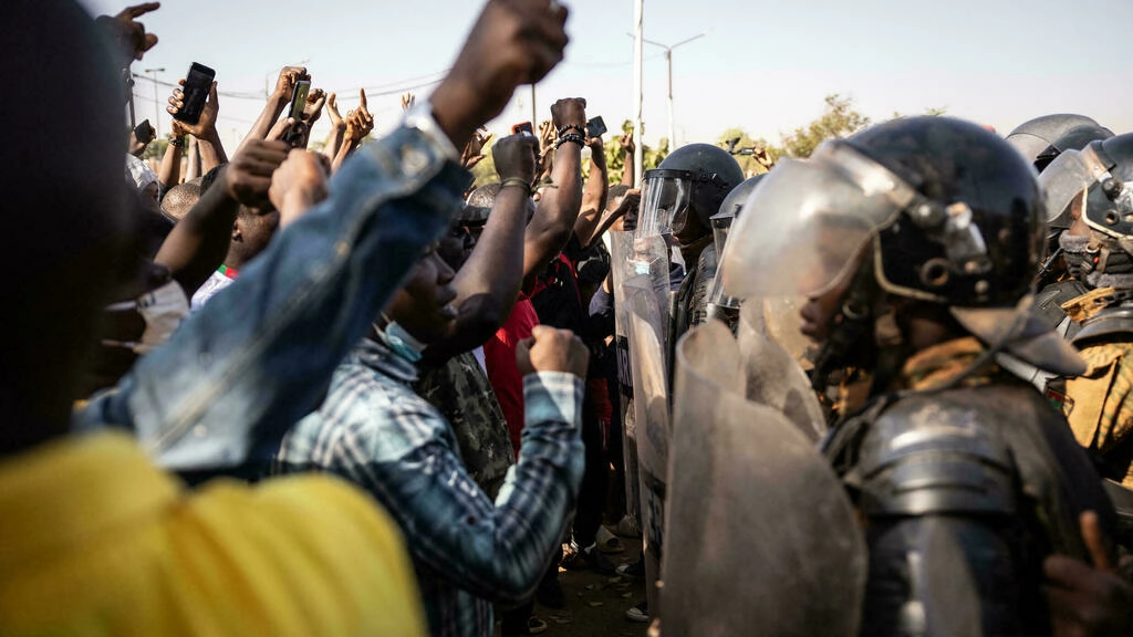Des manifestants face aux forces de sécurité lors d'une manifestation à Ouagadougou le 27 novembre 2021. La police anti-émeute a tiré des gaz lacrymogènes pour empêcher les manifestants de se rassembler sur une place du centre de Ouagadougou, où d'importantes forces de police et de sécurité ont été déployées et tous les magasins fermés. AFP - OLYMPIA DE MAISMONT