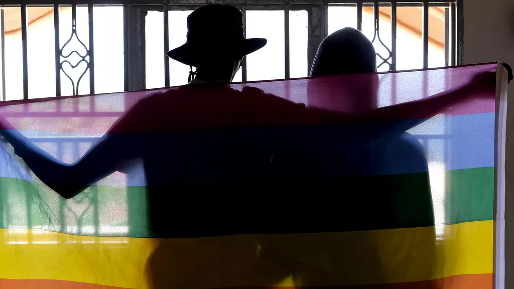 Un couple gay se couvre d'un drapeau arc-en-ciel pour une photo en Ouganda, le 25 mars 2023