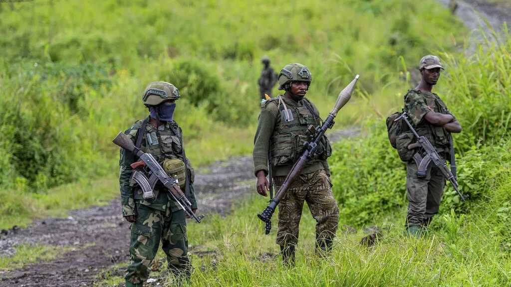Des rebelles du M23 avec leurs armes lors d'une cérémonie marquant le retrait de leurs positions dans la ville de Kibumba, dans l'est de la RDC