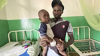 Joshua Jonathan porte son fils Christian, âgé de 9 mois, en convalescence à l'hôpital de Kunji, dans le sud de Kaduna, au Nigéria