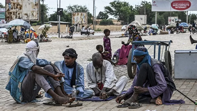 Des personnes sont assises dans une rue de Niamey le 21 août 2023
