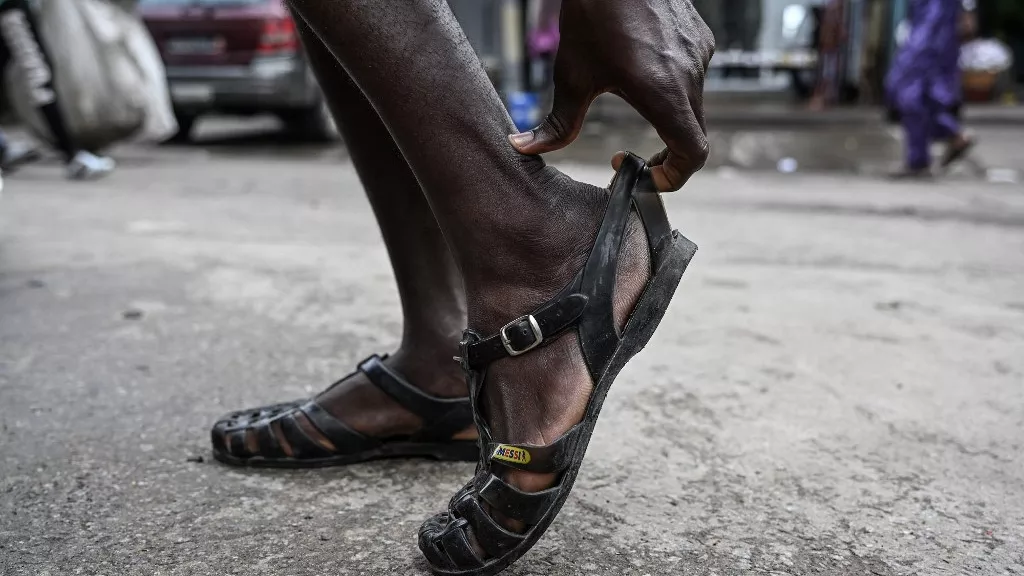 Un homme porte ses chaussures Leke à Treichville, Abidjan, le 14 septembre 2023 - Copyright © africanews SIA KAMBOU/AFP or licensors