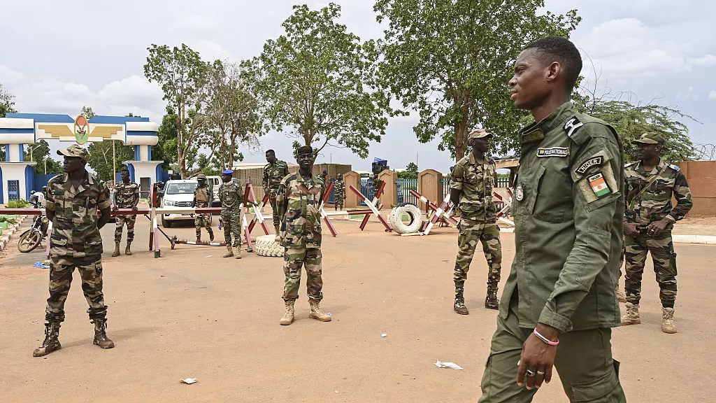 Des soldats nigériens montent la garde alors que des partisans du CNSP se rassemblent pour une manifestation à Niamey, le 11 août 2023, près d'une base aérienne française