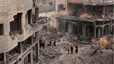 Des Palestiniens inspectent les destructions dans un quartier fortement endommagé par les frappes aériennes israéliennes sur le camp de réfugiés de Shati, à Gaza - Copyright © africanews - AFP