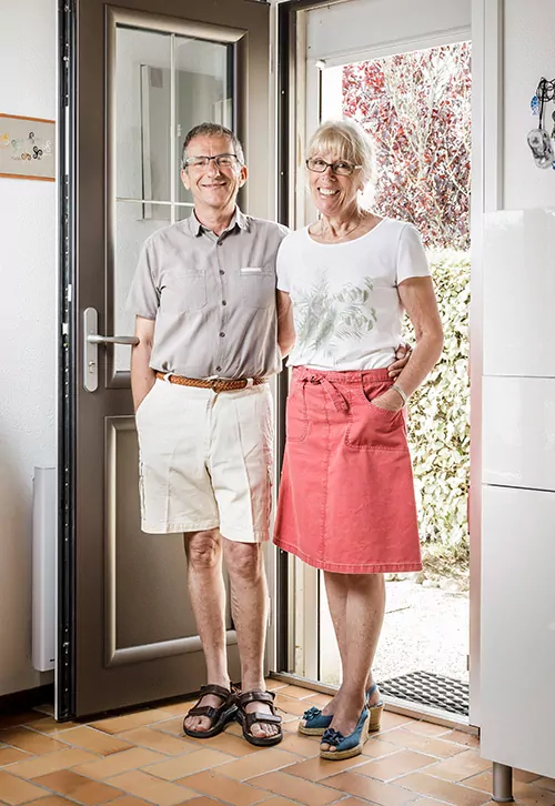 couple de 50 ans debout devant la porte